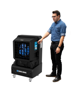 Man demonstrating the Cool Boss CB-12 portable indoor and outdoor evaporative air cooler — a compact, space-saving shop fan with blue blades and durable black housing.