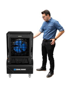 Man standing beside the Cool Boss CB-14SL portable evaporative air cooler — an indoor and outdoor space-saving shop fan with blue blades and black housing.