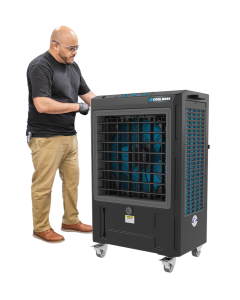 Technician standing next to Cool Boss CB-19SL 5150082 evaporative air cooler for size reference, showing large front vent and portable caster design.