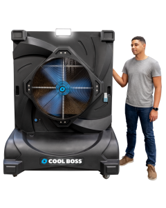 Man standing beside the Cool Boss CB-28 portable indoor/outdoor evaporative air cooler — large space-saving shop-fan with blue blades, LED light, and durable black housing.