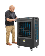 Technician standing next to Cool Boss CB-19SL 5150082 evaporative air cooler for size reference, showing large front vent and portable caster design.