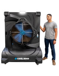 Man standing beside the Cool Boss CB-28 portable indoor/outdoor evaporative air cooler — large space-saving shop-fan with blue blades, LED light, and durable black housing.