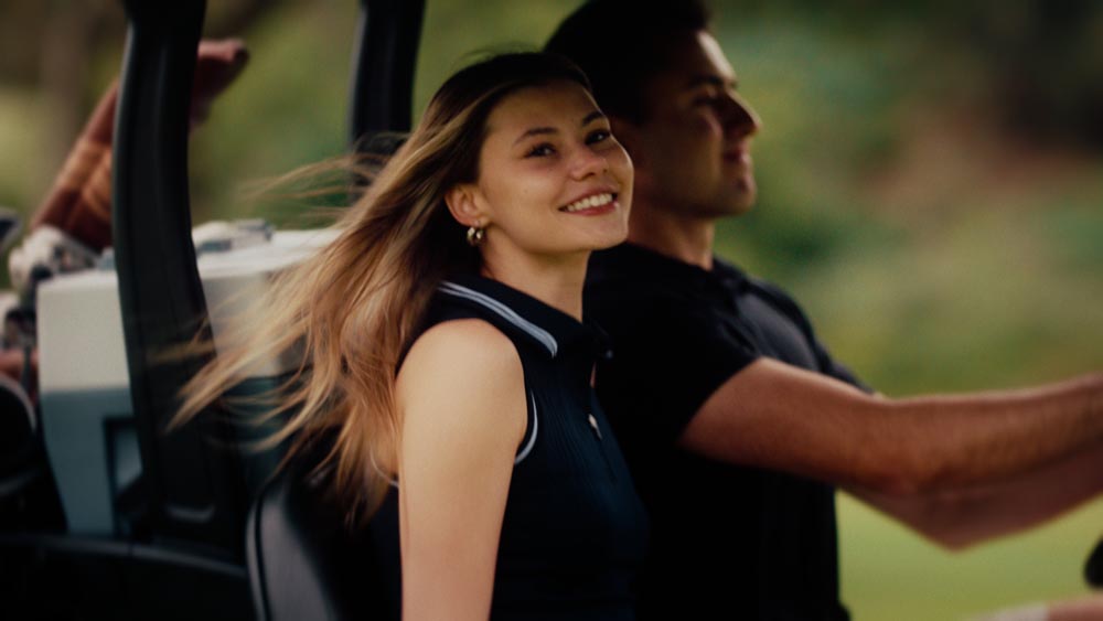 Golfers riding in a golf cart equipped with a Coolee Tour LX portable air conditioner.